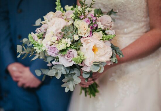 A person in a wedding dress holds a bouquet