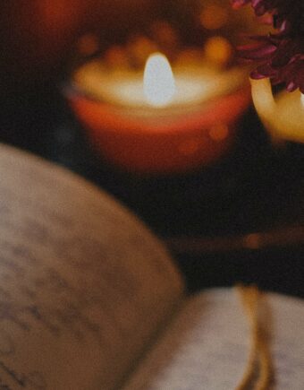 A notebook dimly lit by a candle