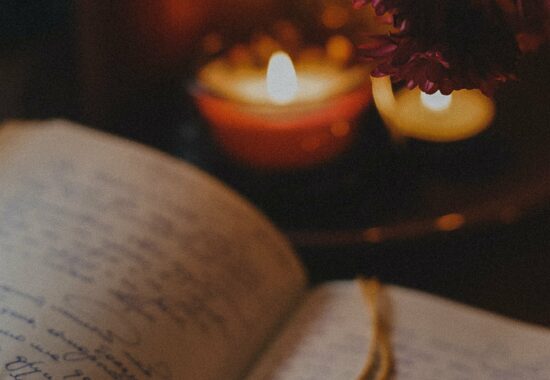 A notebook dimly lit by a candle