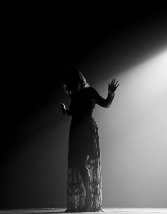 Woman in black dress standing on stage