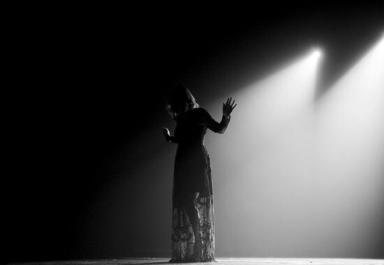 Woman in black dress standing on stage