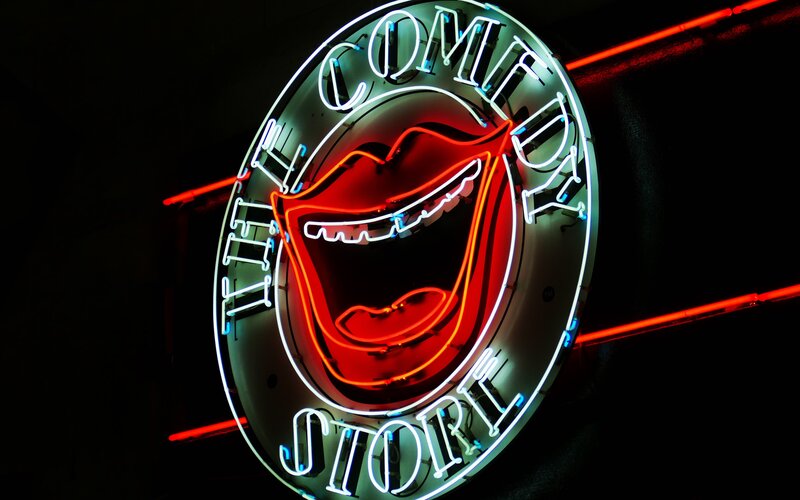 A neon sign for a comedy club
