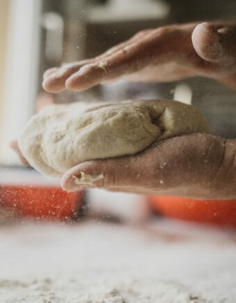 Two hands hold dough