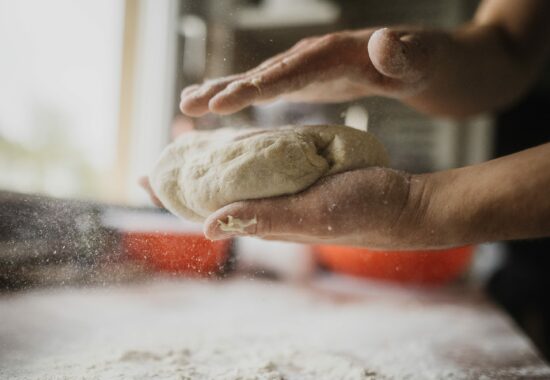 Two hands hold dough