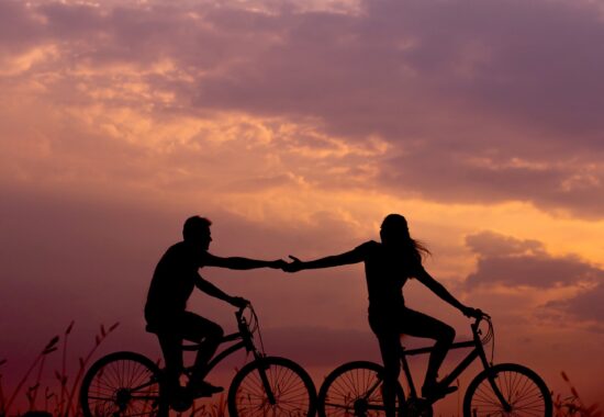 Two people ride together in sunset