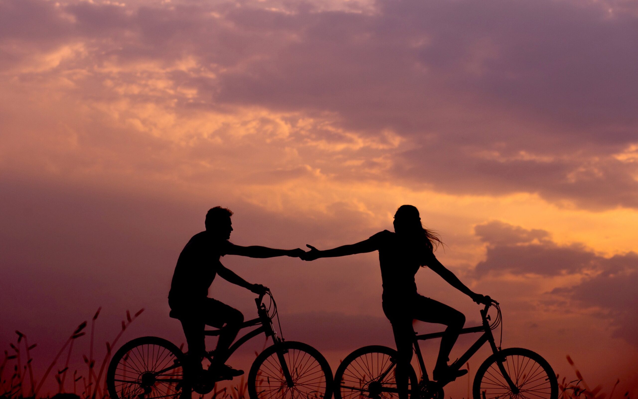 Two people ride together in sunset
