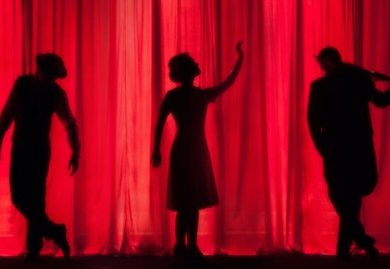 3 people in silhouette posing on stage