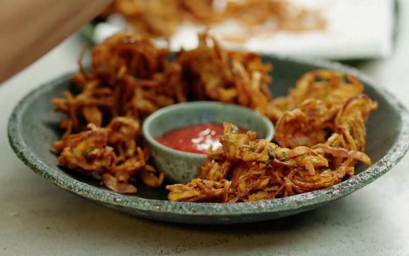 Onion Bhajis on a plate with ketchup