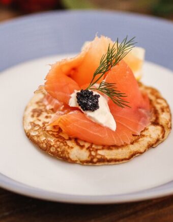 salmon blini on a blue and white plate