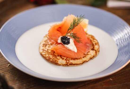 salmon blini on a blue and white plate