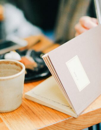 A coffee up and notebook on a table