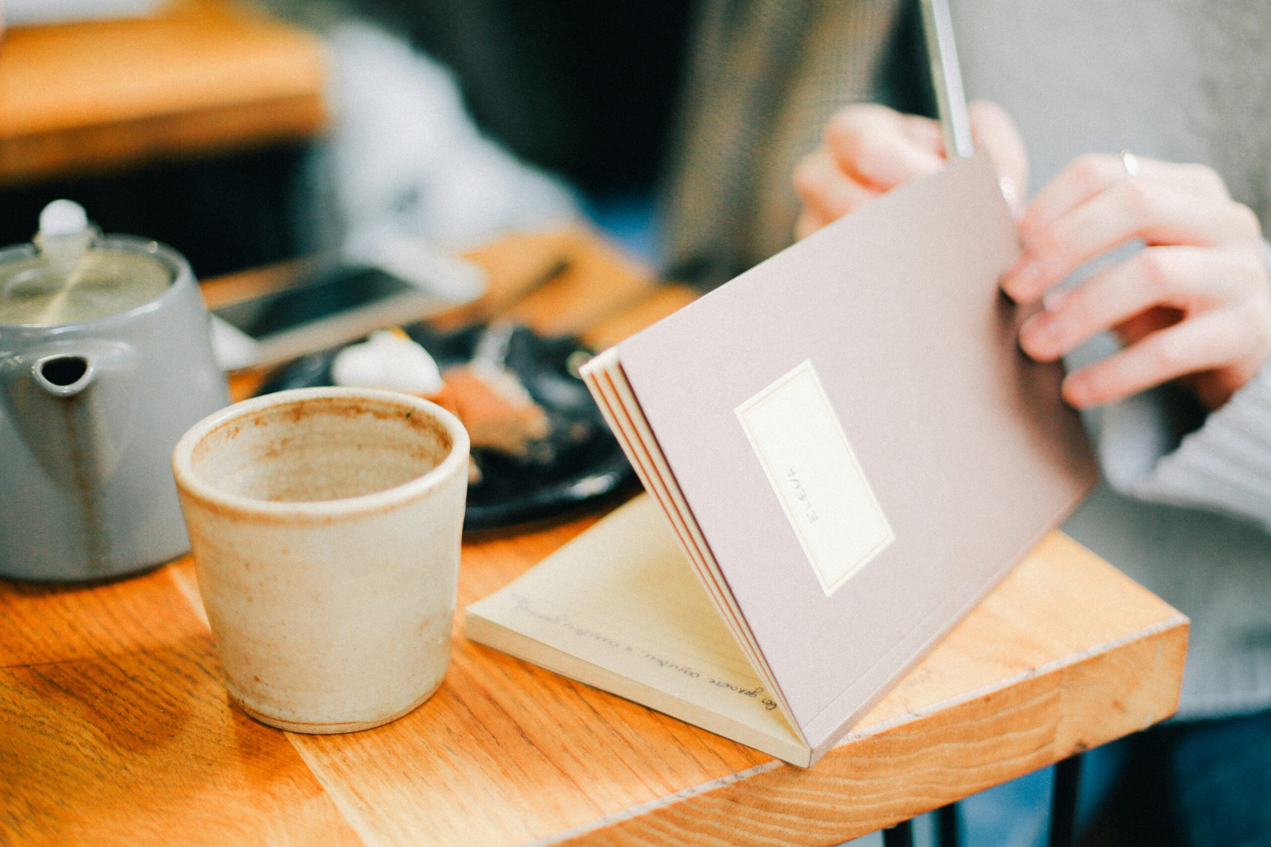 A coffee up and notebook on a table