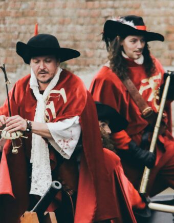 Two people performing in red coats