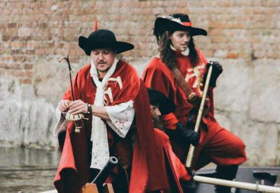 Two people performing in red coats